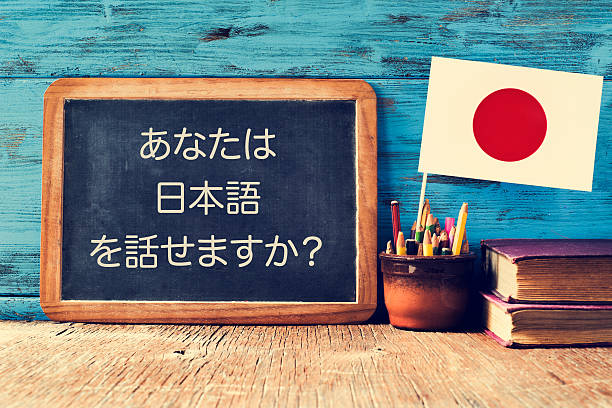 Fotografía de una bandera japonesa junto a un tablero con caracteres japoneses escritos.